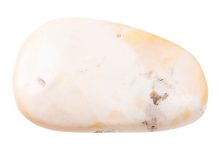 closeup of sample of natural mineral from geological collection - polished pink opal gemstone isolated on white background